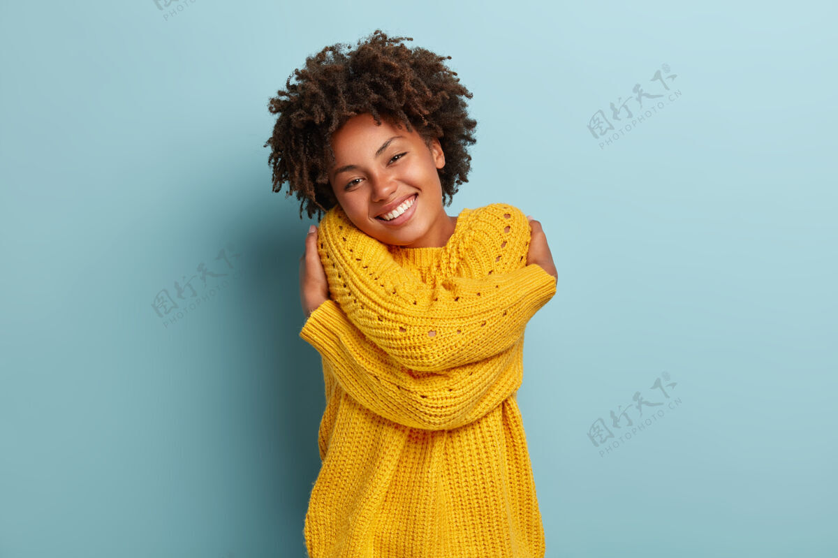 满足一个穿着粉色毛衣的非洲裔可爱女人女士快乐女性