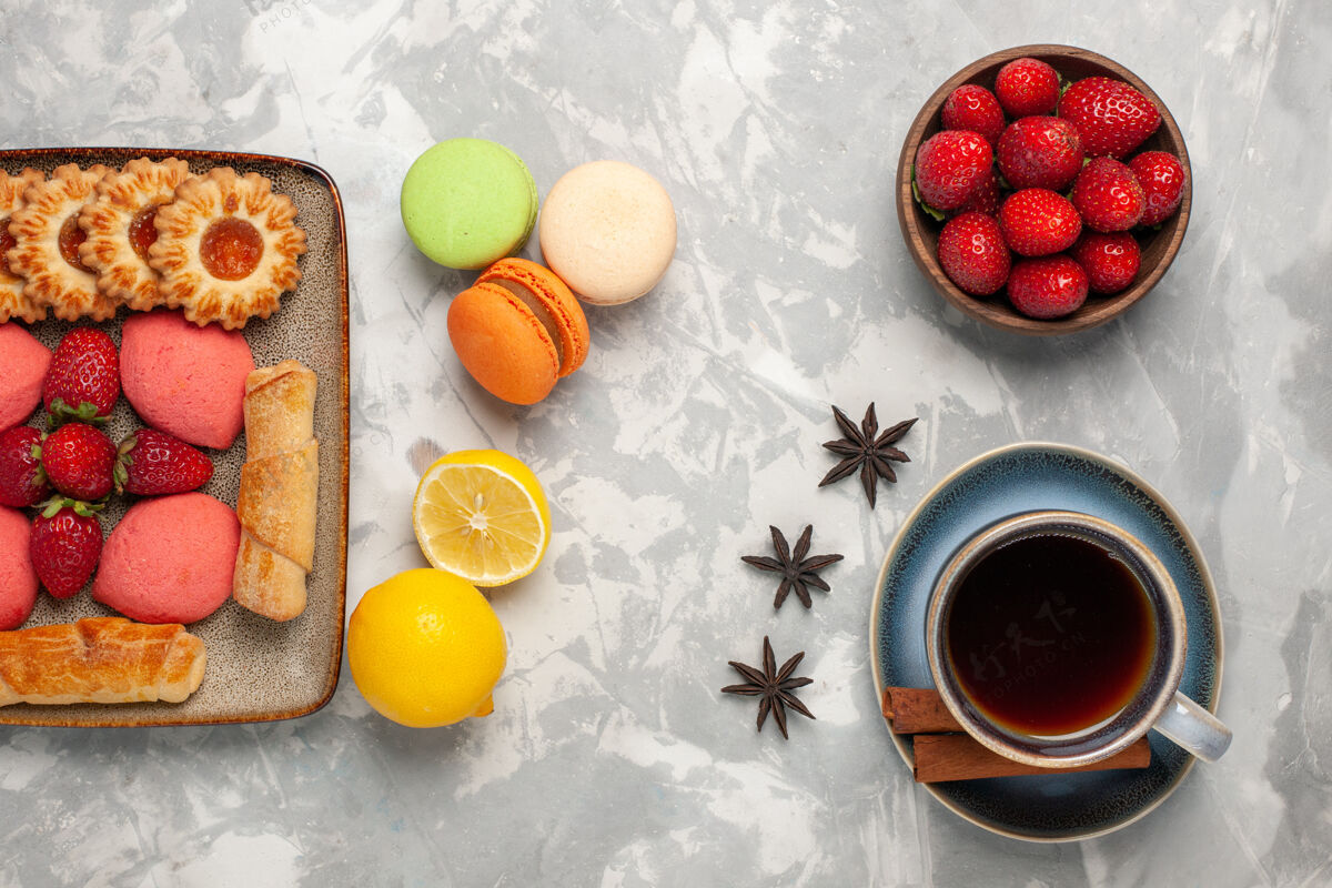 草莓白色桌面上有美味的百吉饼 蛋糕 新鲜草莓 茶和饼干早餐生的美味