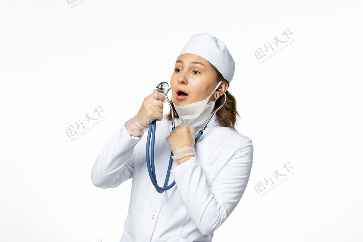 病毒正面图年轻女医生戴着无菌防护口罩因白色书桌上有冠状病毒疾病面罩冠状病毒