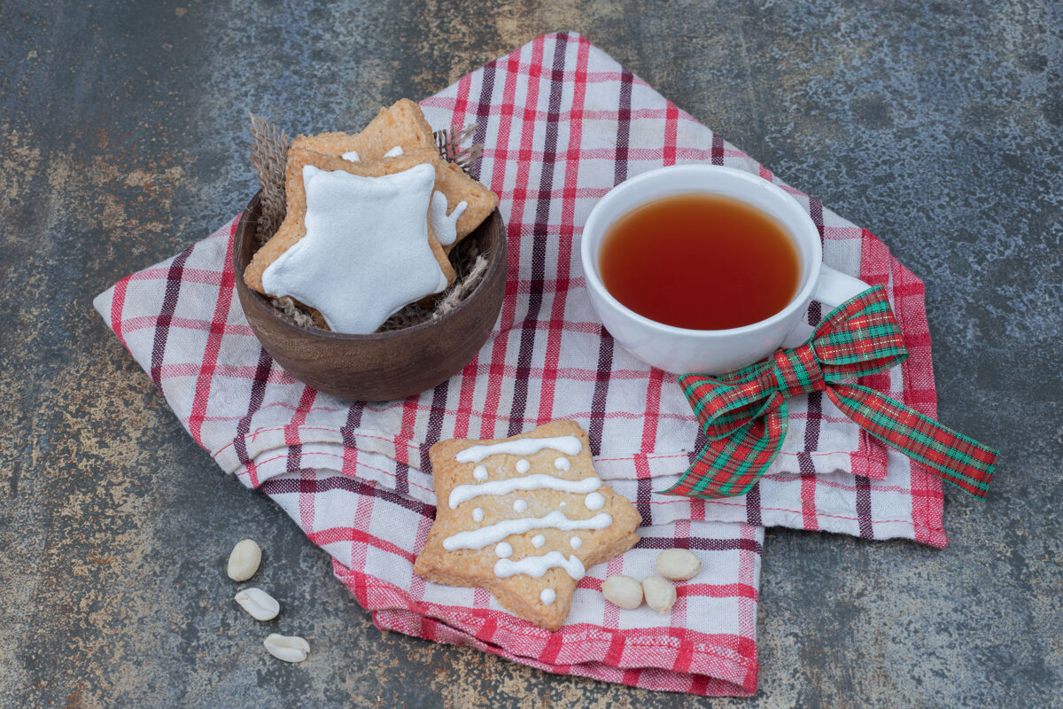 甜点星型姜饼饼干和一杯茶在桌布上高品质的照片圣诞节饼干茶