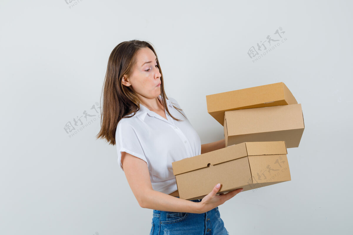 休闲美丽的女士拿着白色衬衫的盒子 看起来很不安 正前方的景色女人年轻盒子