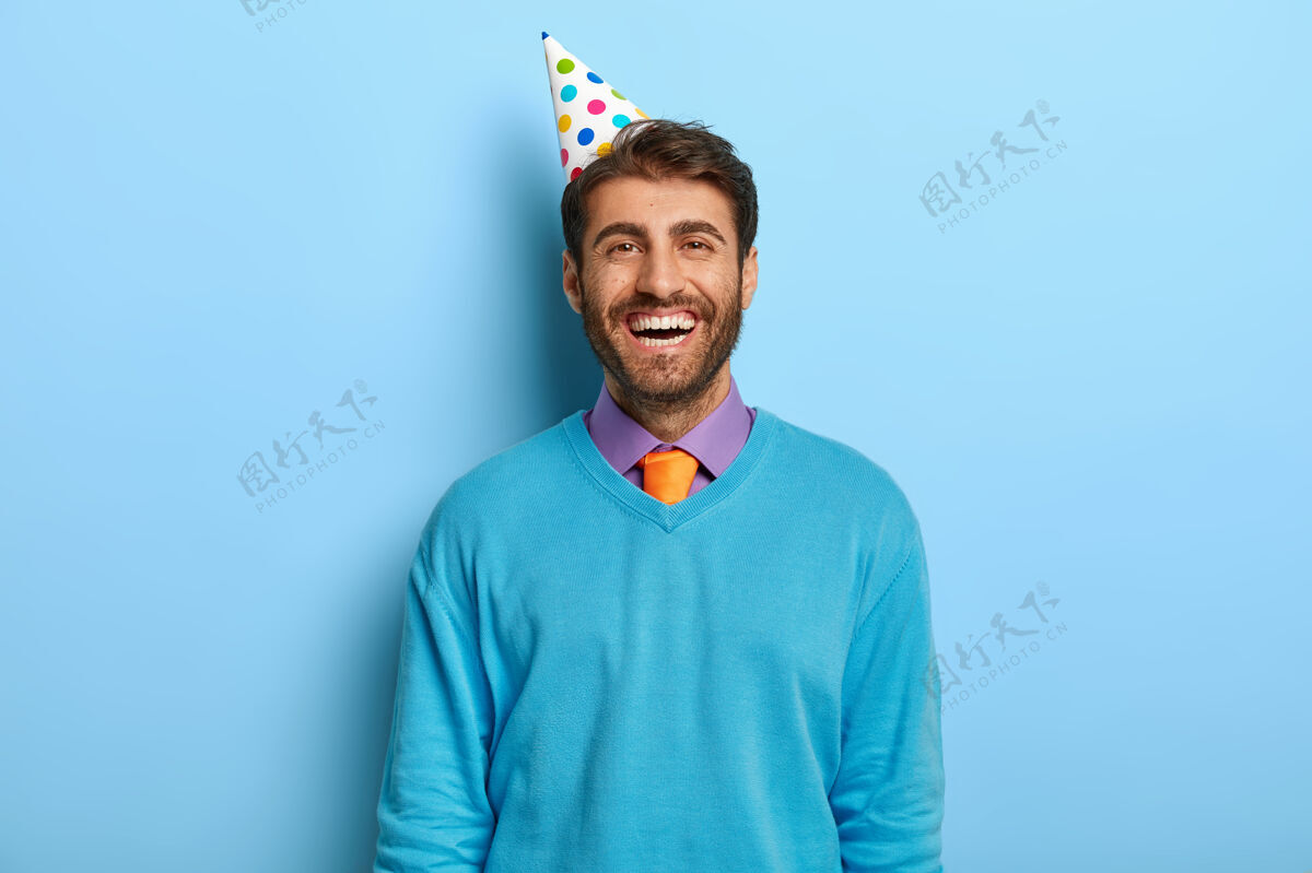 站一个戴着生日帽 穿着蓝色毛衣的开朗乐观的家伙满意积极欢呼