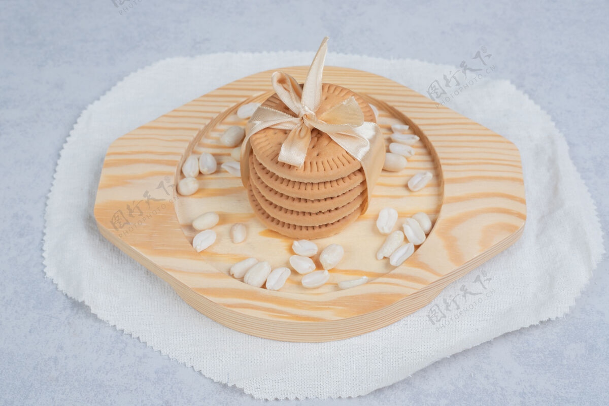 蝴蝶结一堆节日饼干和花生放在木盘上高质量的照片面包房甜点丝带