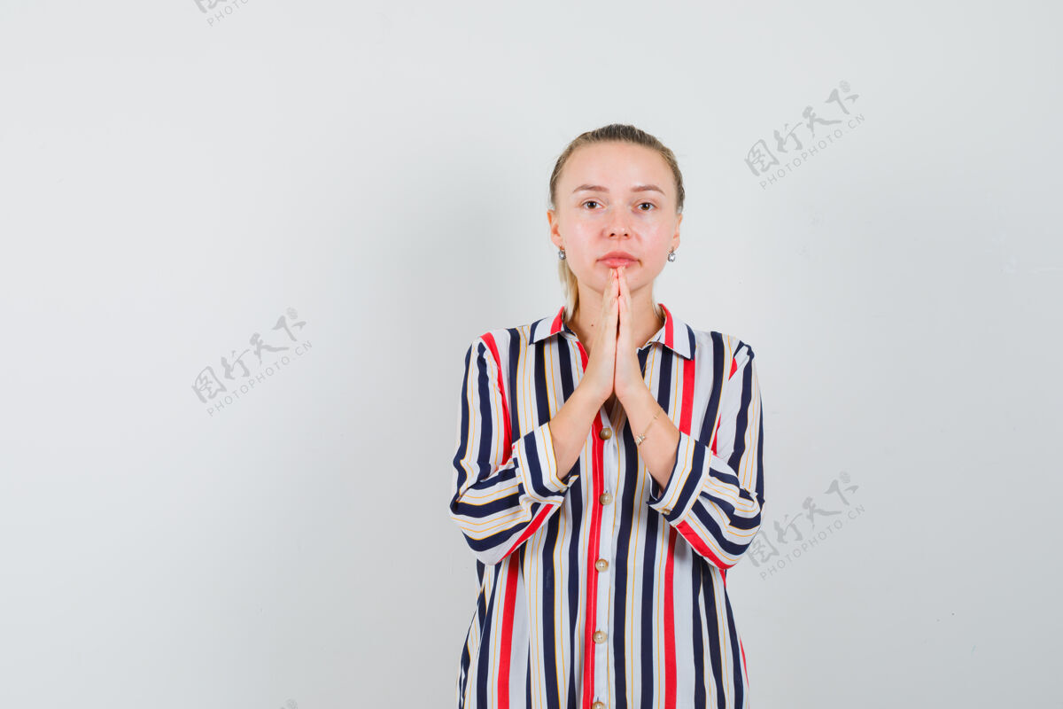祈祷身穿条纹衬衫的年轻女士手牵手祈祷 看上去充满希望时尚欢呼喜悦