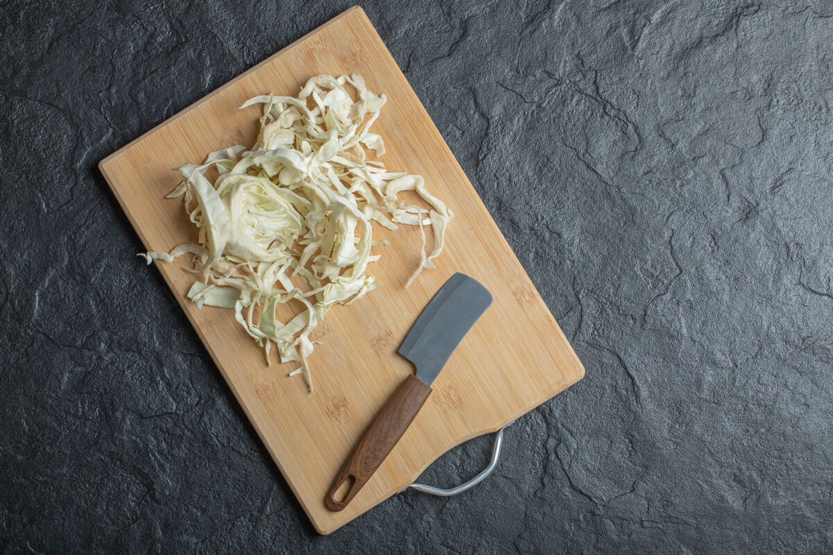 自然切碎的卷心菜和刀在木制砧板上的照片高品质的照片一半菜木材