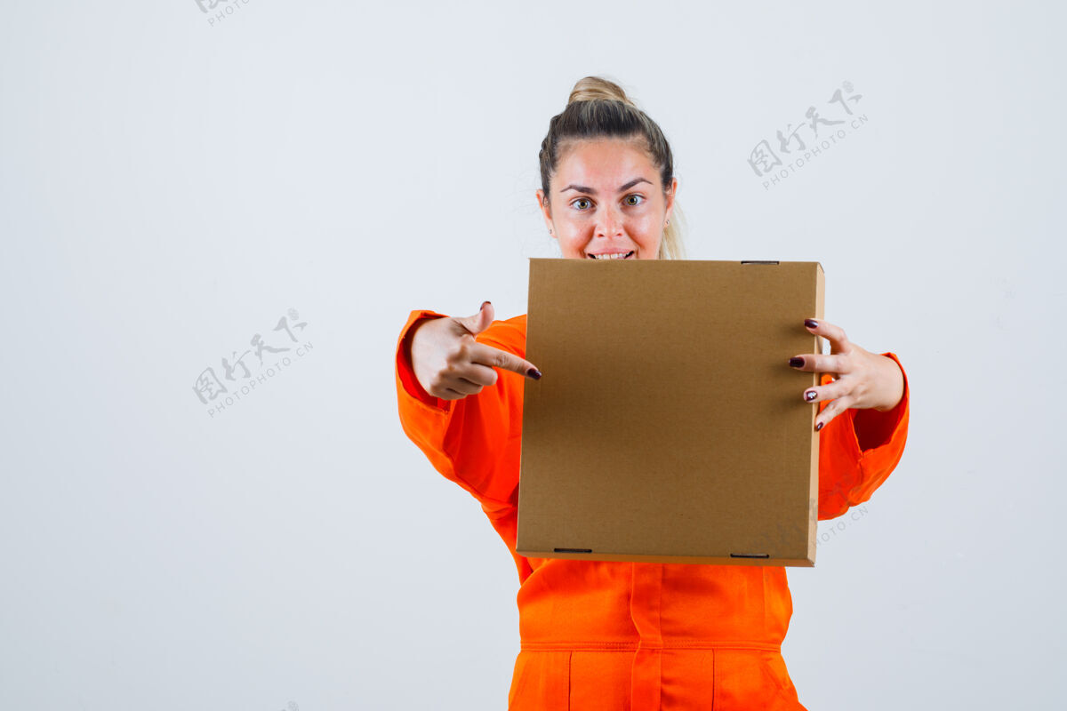 女人年轻的女性指着穿着工人制服的盒子 正面看去制服积极工人