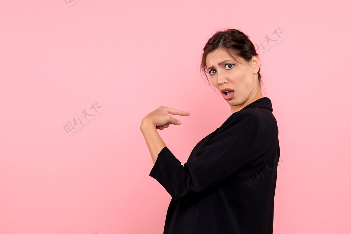 成人正面图年轻女性穿着粉色背景的深色夹克夹克西装商务