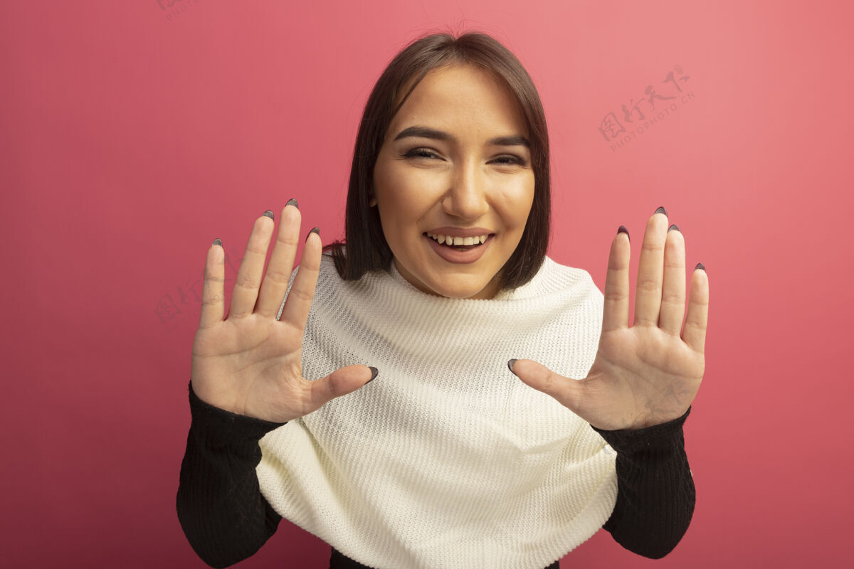 投降戴着白领巾的年轻女子举手投降 愉快地微笑着看站女人