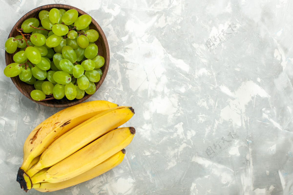 热带顶视图新鲜的黄色香蕉醇香可口的水果和葡萄在浅白色的办公桌上食品水果醇香