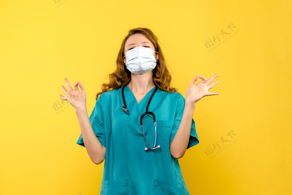 面罩黄色空间里戴着面具的女医生的正视图医院诊所前面