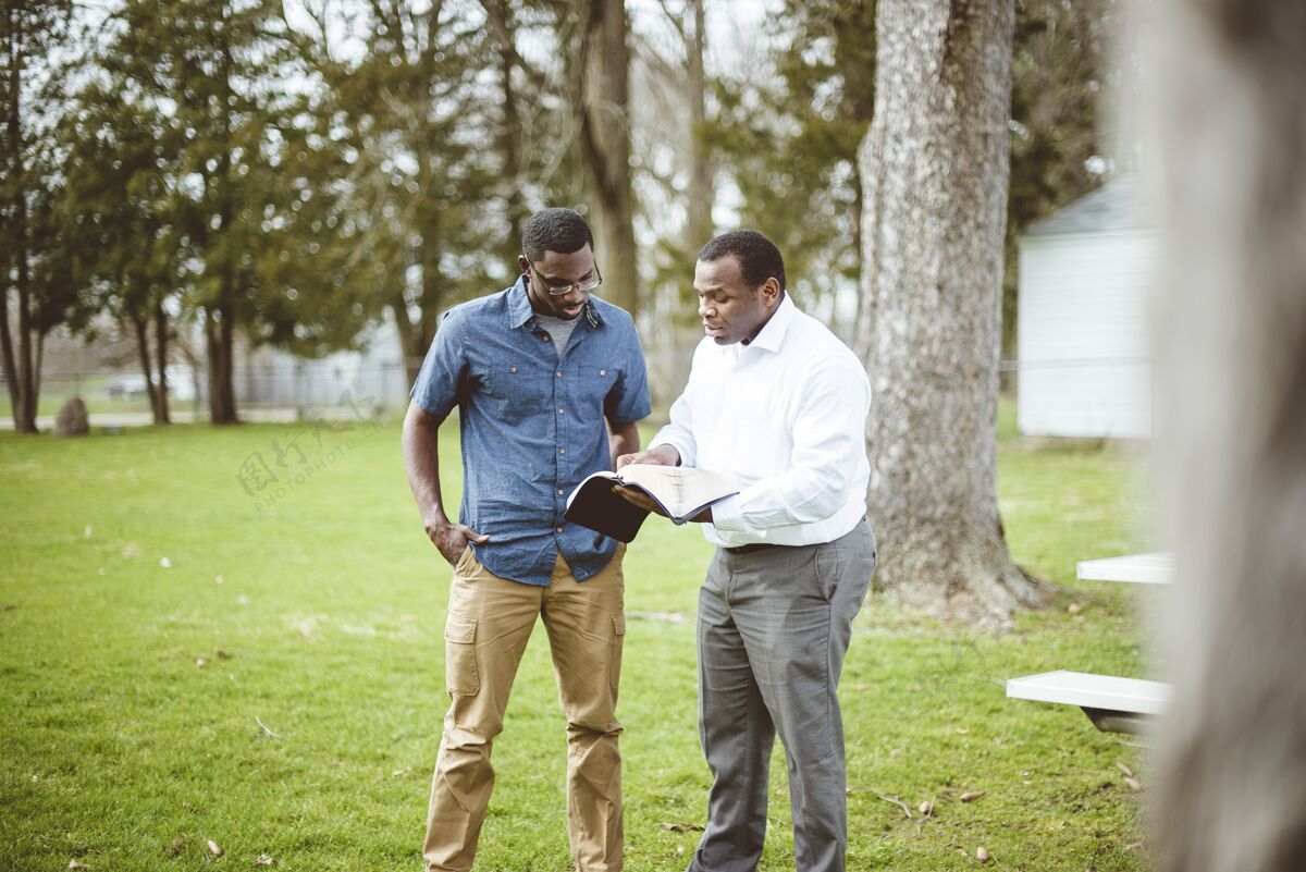 信仰非洲裔美国男性朋友站在公园里讨论圣经男人男性精神