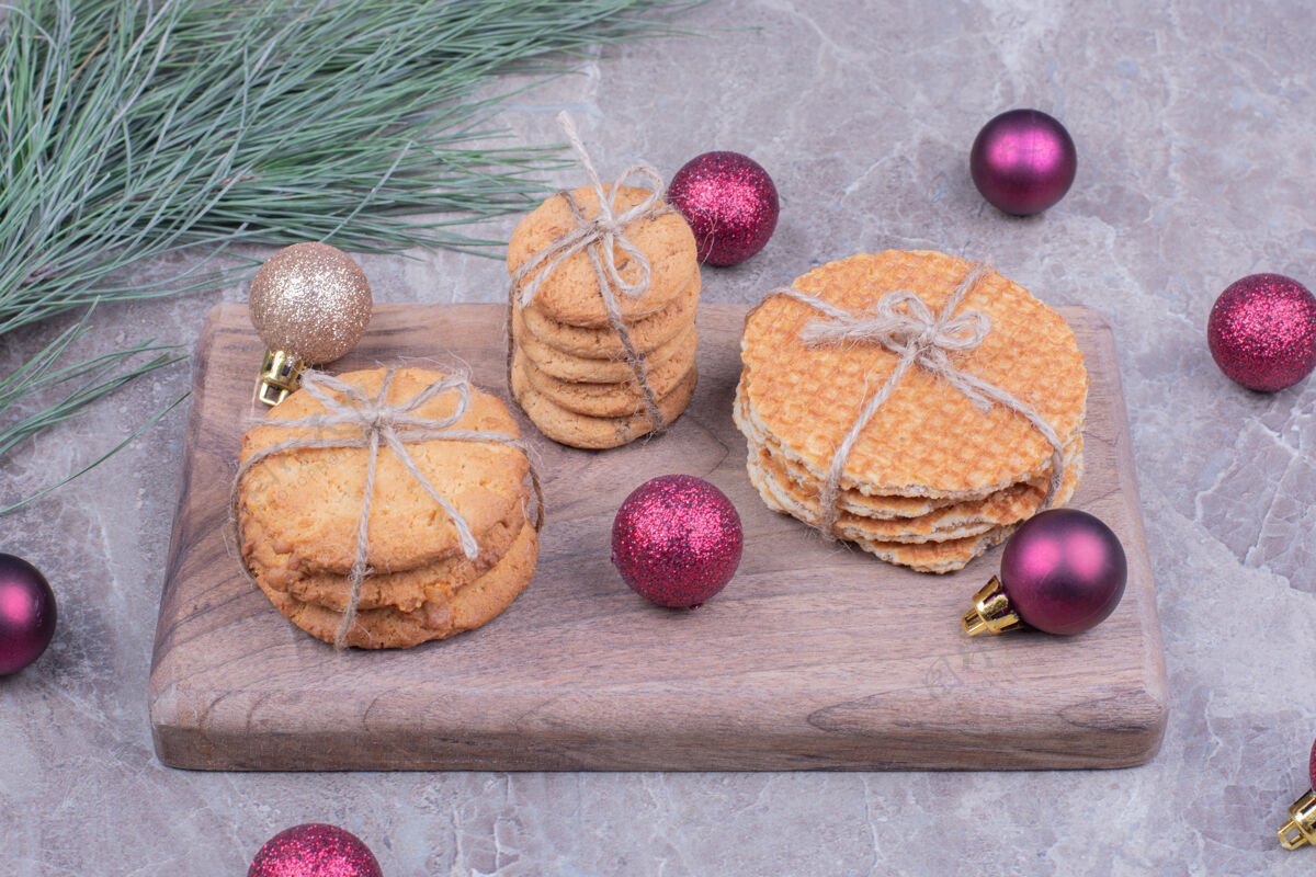 糕点放在木板上的饼干 周围放着闪闪发光的红色圣诞球面包房健康喜悦