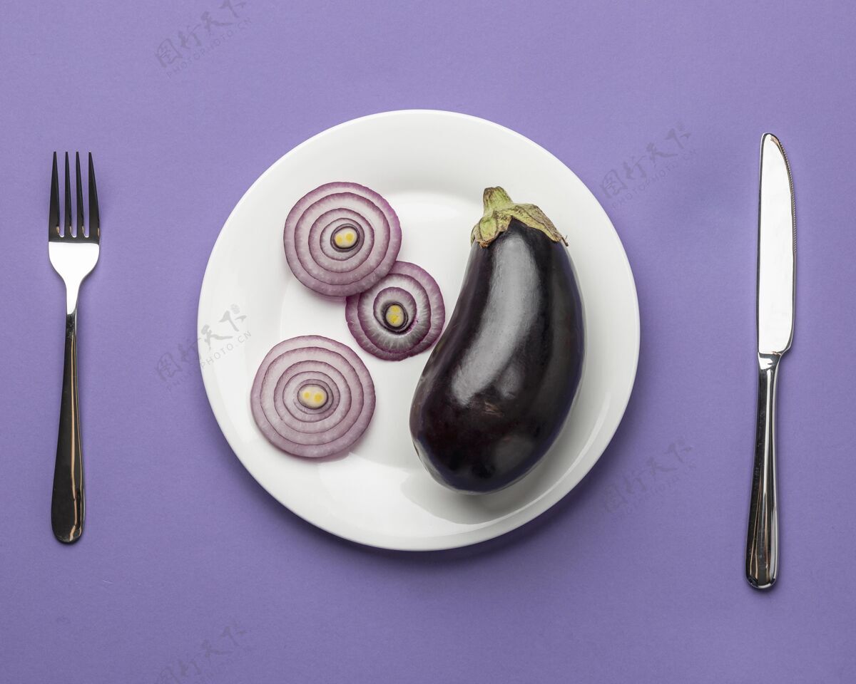 营养茄子和洋葱的顶视图放在盘子里 还有餐具刀食品营养