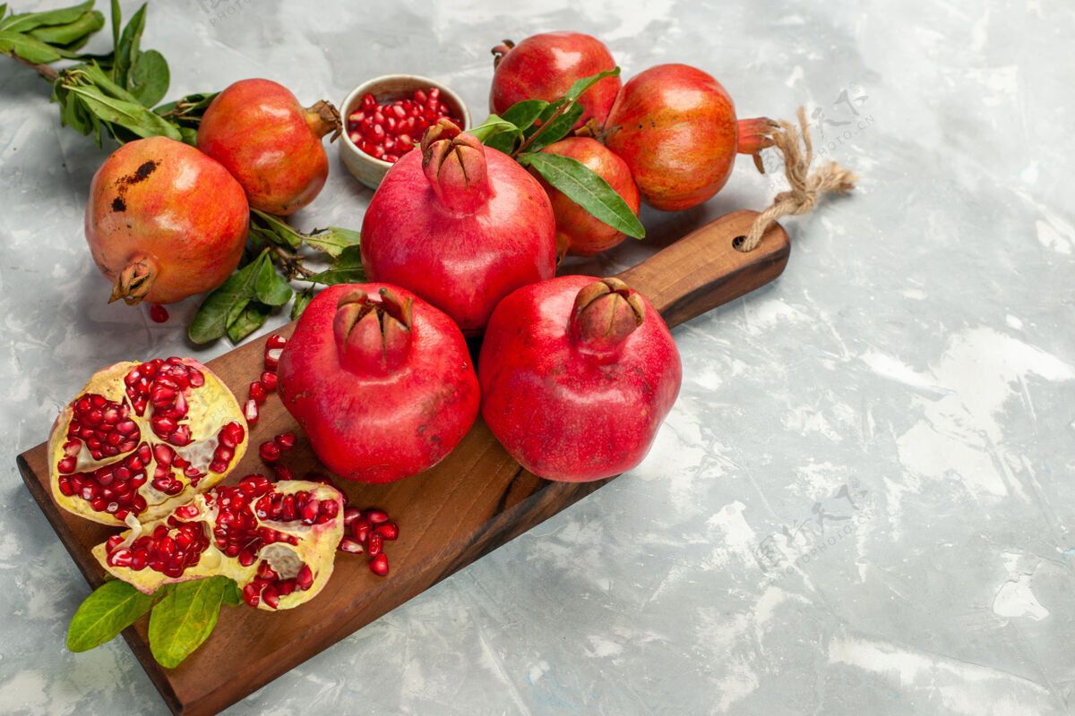 苹果半顶视图新鲜的红石榴 酸而醇厚的水果 浅白的桌子上的水果 新鲜醇厚的成熟的树清淡观赏可食用的水果