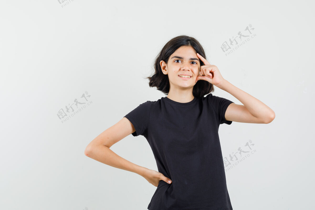 和平穿黑色t恤的小女孩站在思考的姿势 看起来乐观 正面视图女性成人未成年