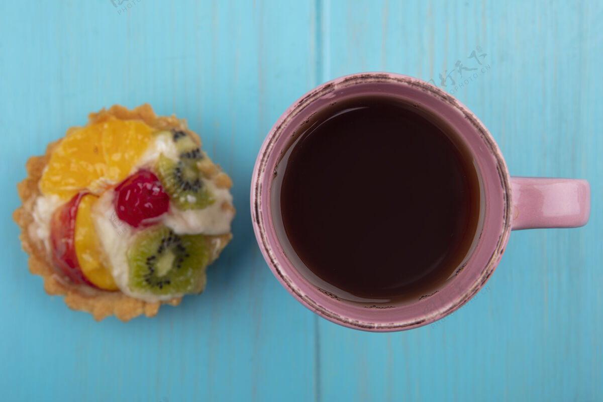 杯子在蓝色木制背景上 一杯茶可以俯瞰美味的水果馅饼水果景观食物