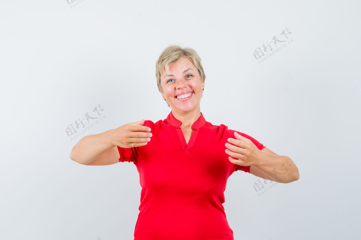 可爱成熟的女人穿着红色t恤假装拿着东西 看起来很开心假装成熟欢呼