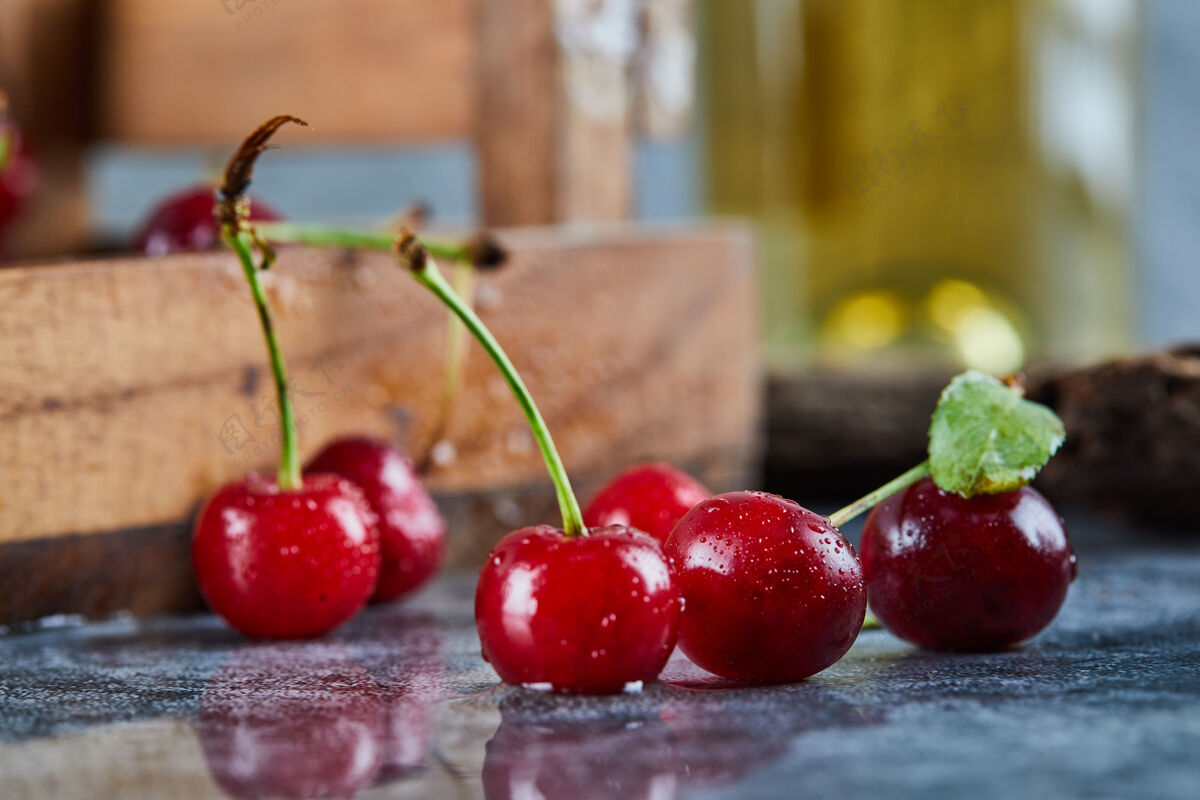 新鲜红色多汁的樱桃浆果放在蓝色的桌子上木材多汁酸