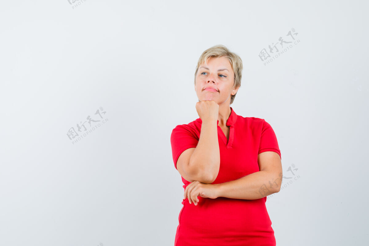 白发一个穿着红色t恤的成熟女人举起拳头托着下巴 看起来很沉思脸看成熟
