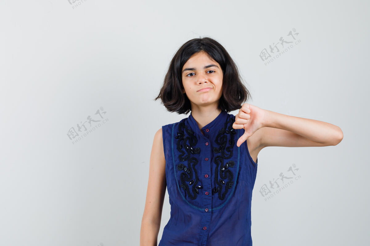 好看穿蓝色上衣的小女孩垂着大拇指 看上去很不满意青少年显示欢呼