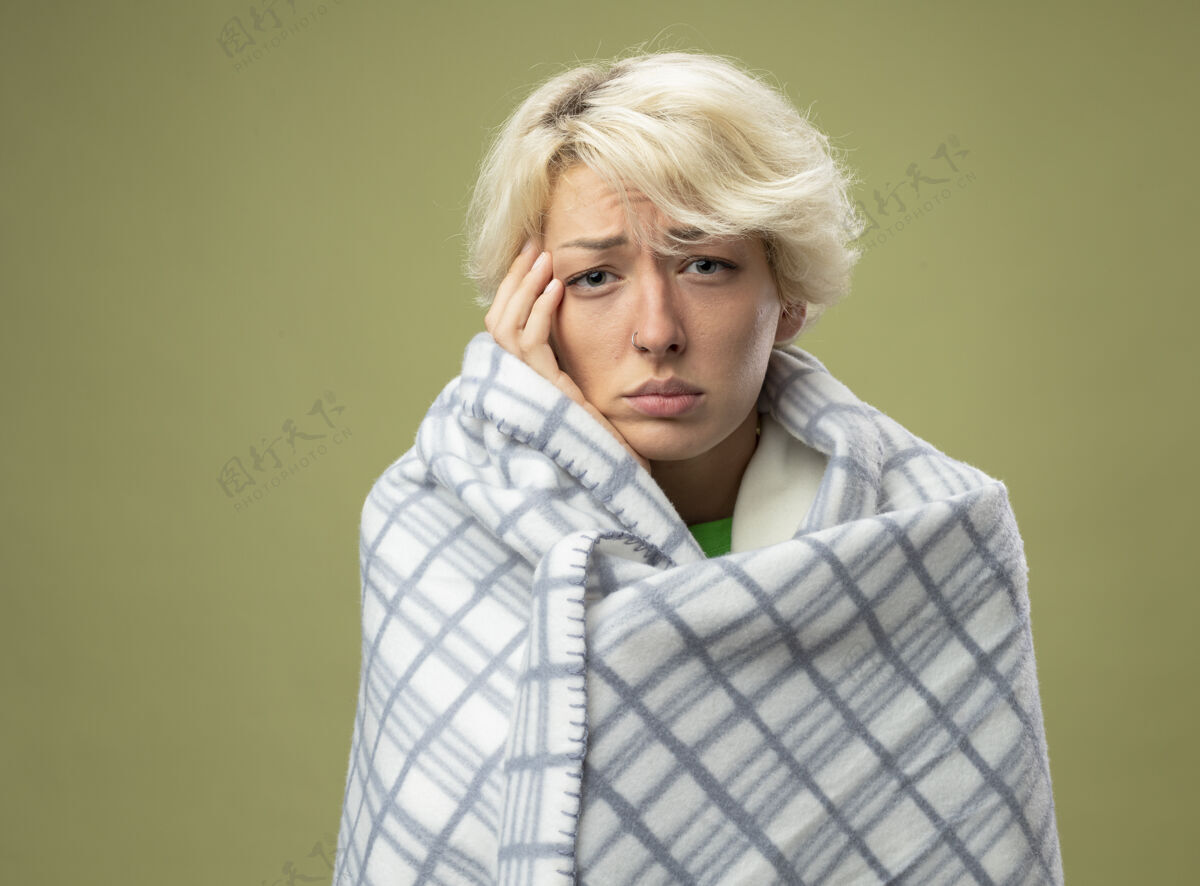 光有病的不健康的妇女 短发 裹在毯子里感觉不舒服 看起来像是患了流感 站在光墙上碰头短裤头女人