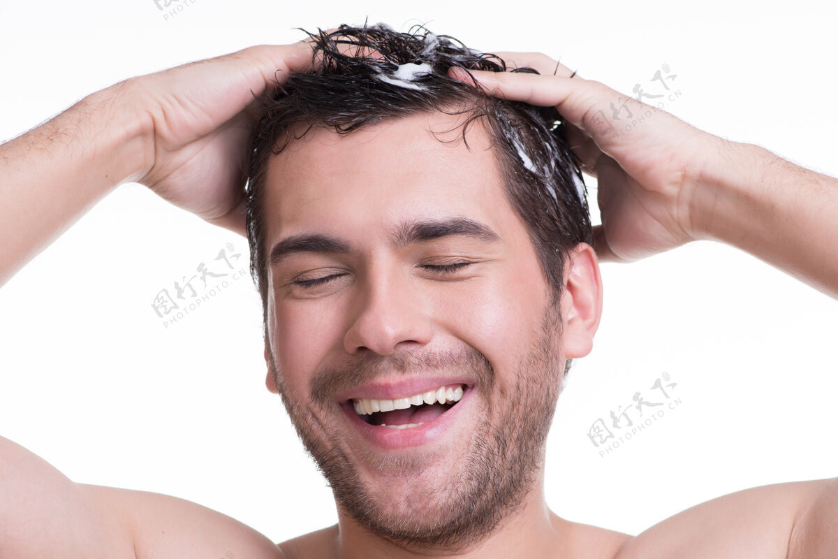 站立年轻快乐微笑的男人闭着眼睛洗头发-孤立的白色大笑帅哥浴室