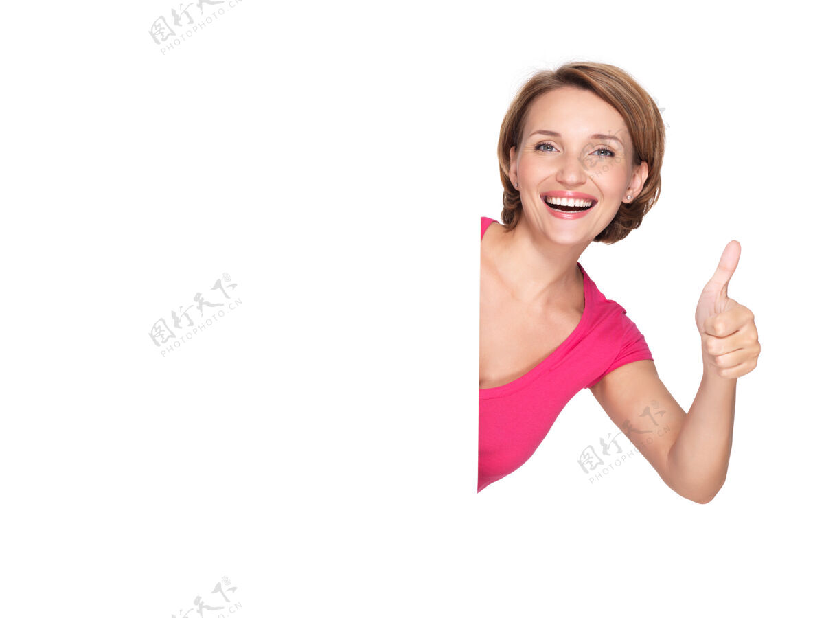 大拇指一个美丽的成年快乐女人的肖像与横幅显示竖起大拇指的标志年轻表演向外看