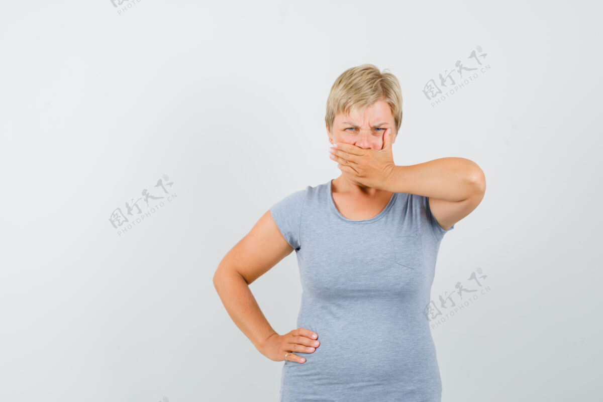 肖像一个穿着灰色t恤 手放在嘴上的成熟女人 看起来很固执积极顽固持有