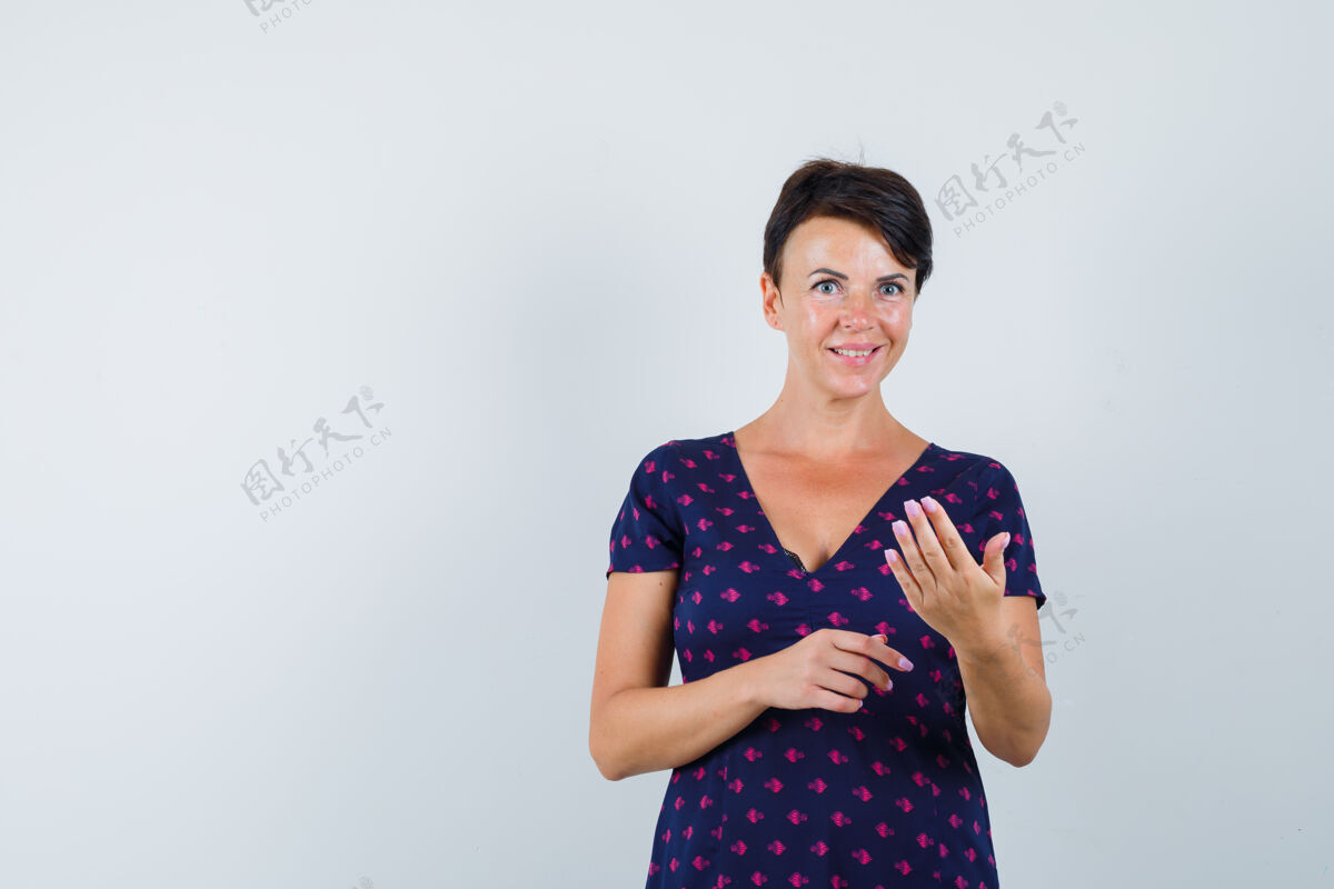 手指黑发女人穿着紫色和红色图案的连衣裙 用手指做单片眼镜 看起来很迷人 正面视图制造打扮成人