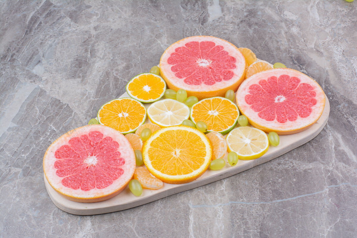 橙子柑橘水果片和葡萄放在木板上健康美味柚子