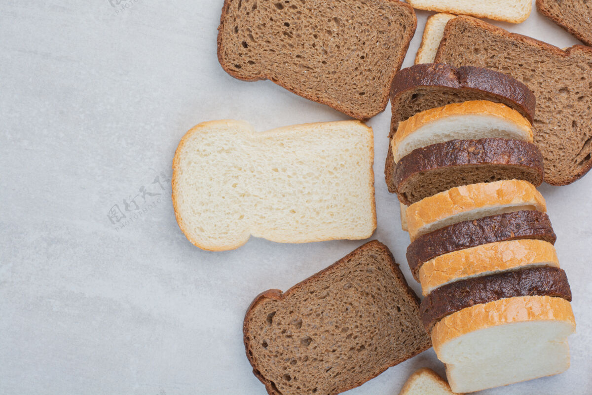 新鲜新鲜的白色和棕色面包片放在大理石背景上面包片糕点面包