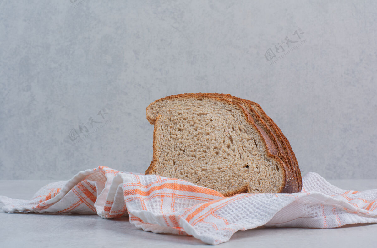 面包切片把新鲜的棕色面包片放在桌布上烘焙新鲜面包