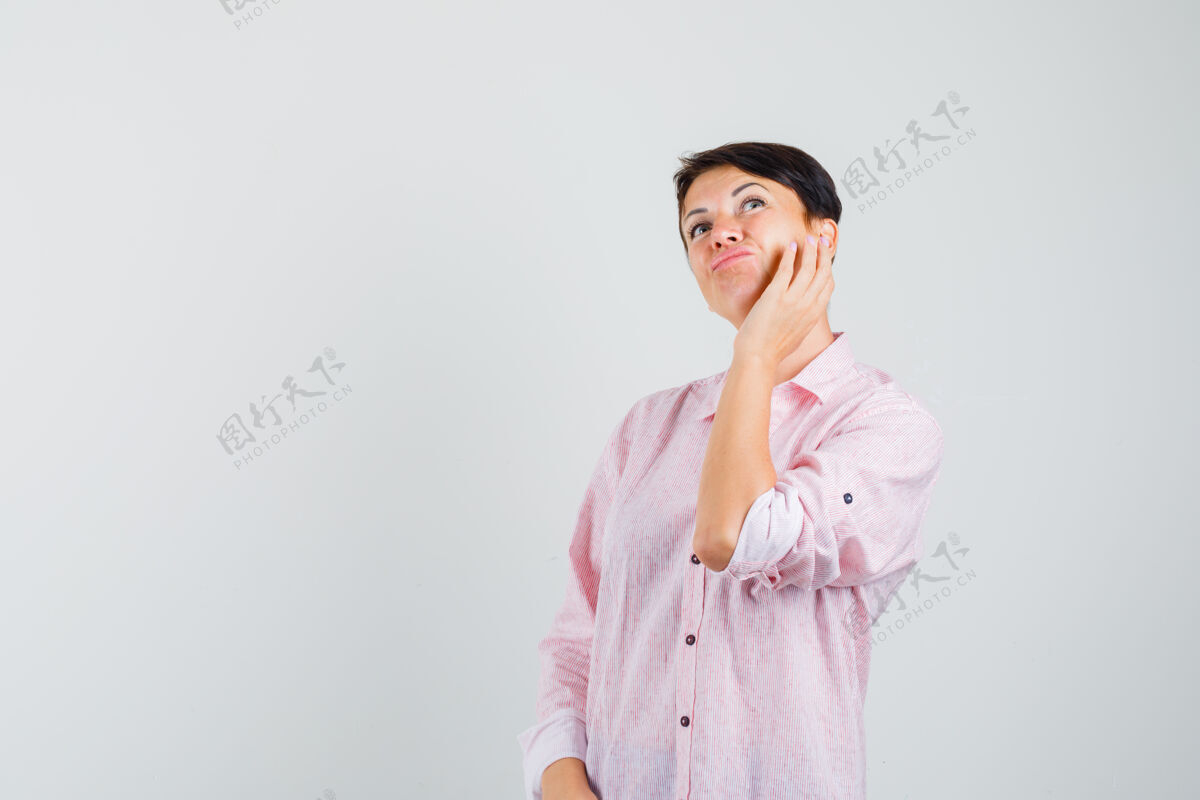 保护穿着粉色衬衫的女性抚摸着脸颊上的皮肤 看上去沉思着前视图成年人爆发脸颊