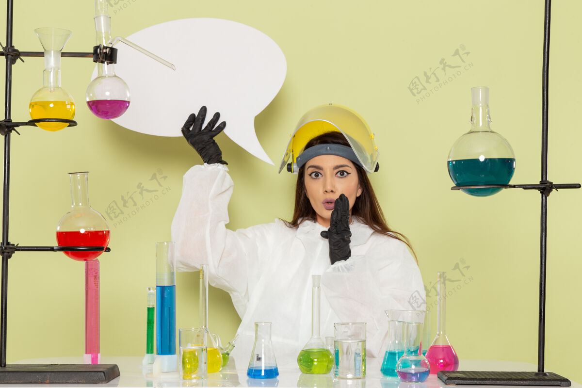 保护正面图身着特殊防护服的女化学家手持浅绿色表面的白色大标牌化学女大