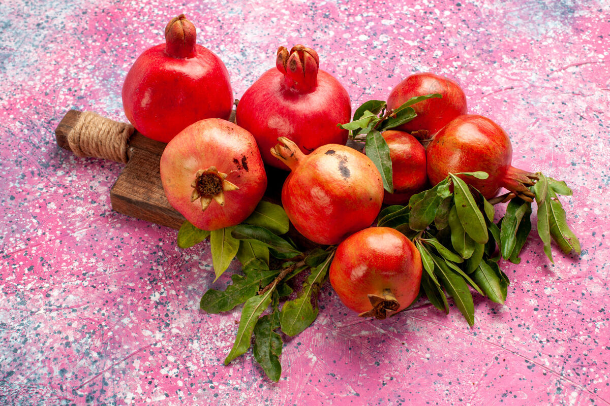 农产品正面是新鲜的红色石榴 粉红色的表面有绿叶健康生的食品