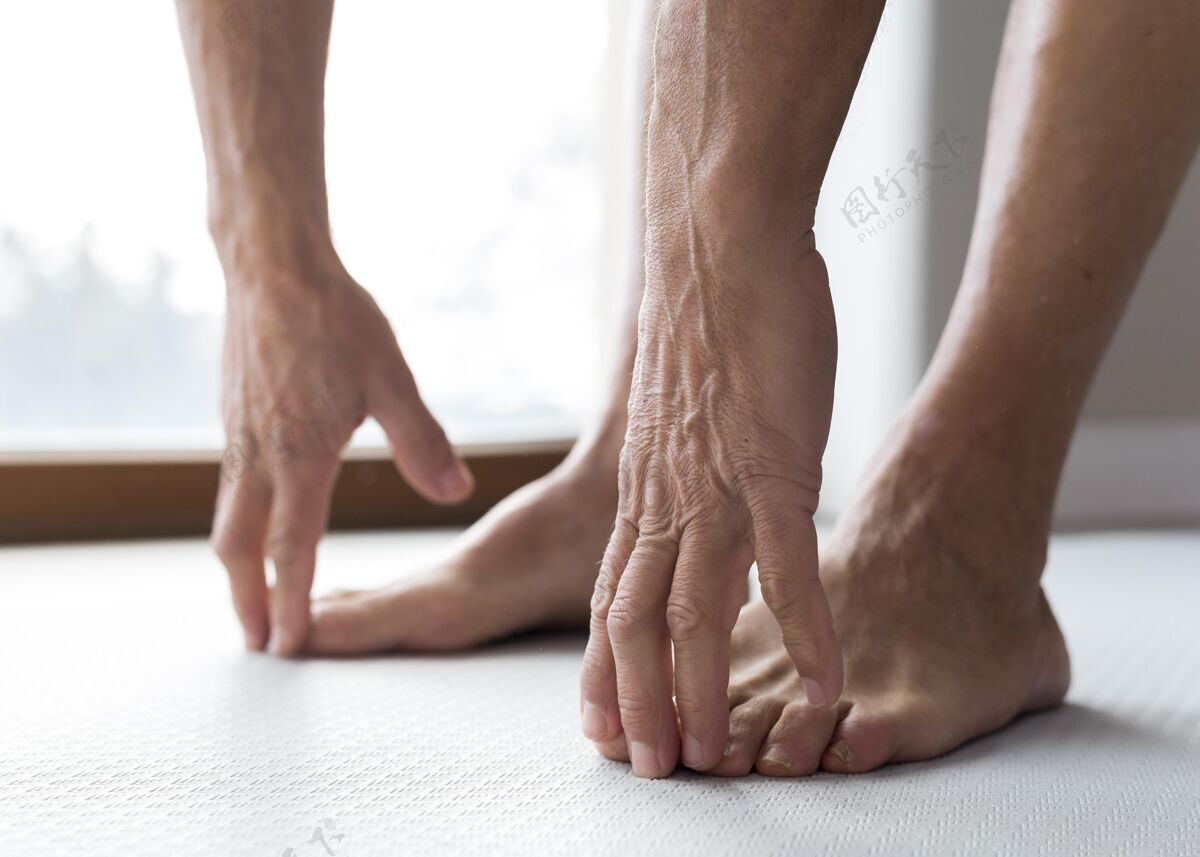 老年健身闭上一个老人的腿和手运动成熟老年人