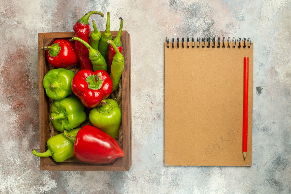 蔬菜顶视图红色和绿色的辣椒辣椒在木箱笔记本红色铅笔裸体表面顶部笔记本胡椒