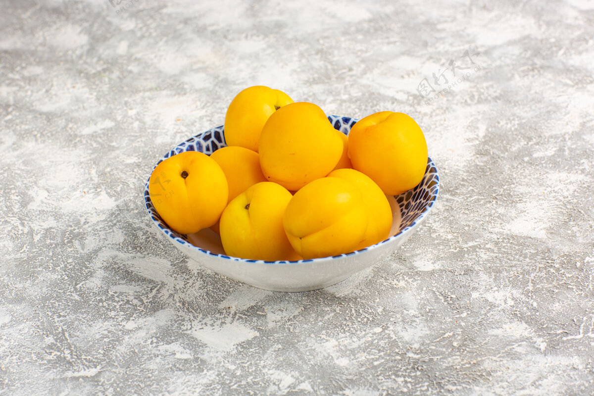 正面正面图新鲜甜杏黄色水果盘内白色表面杏子里面水果