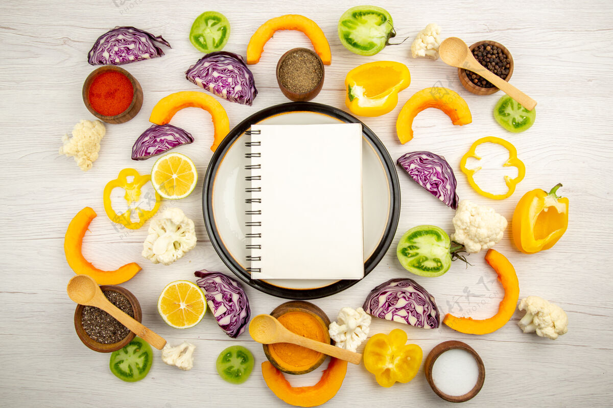 托盘顶视图笔记本上的圆形盘子切蔬菜不同的香料在小碗在白色的木制表面早餐圆形蔬菜