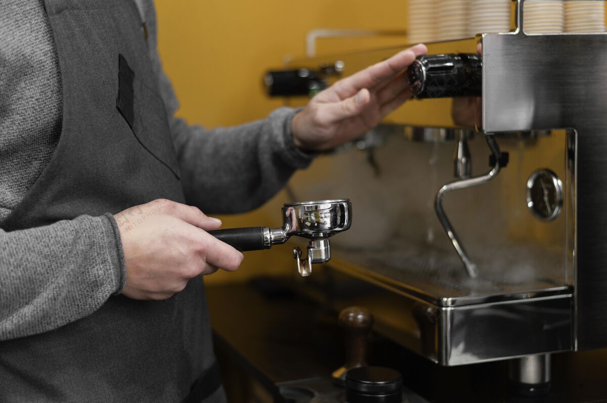 咖啡师男咖啡师侧视图 带围裙 使用专业咖啡机服务员专业男性