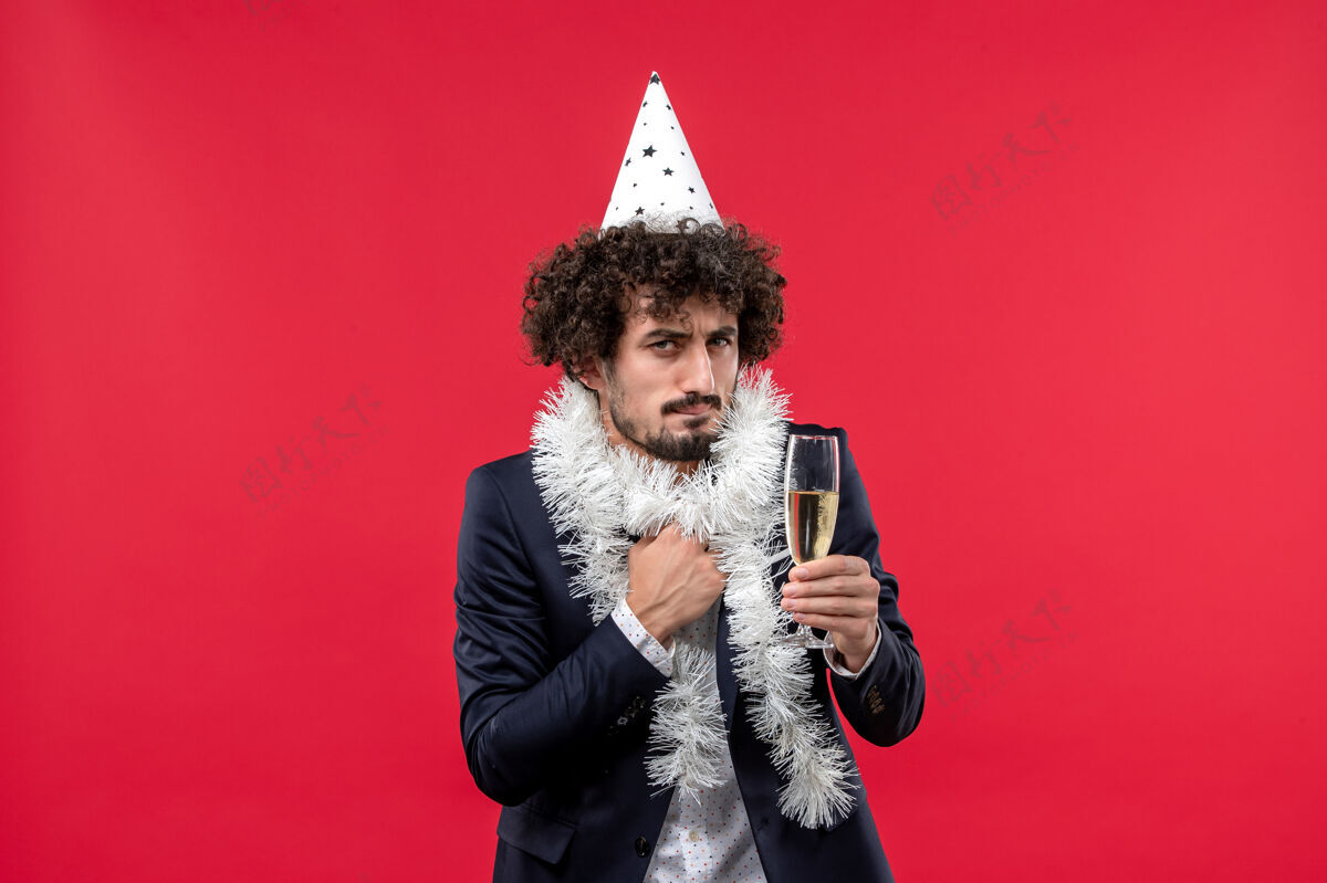 歌手正面图：年轻男性在红墙人类节日派对上庆祝又一年圣诞节年轻男性肖像