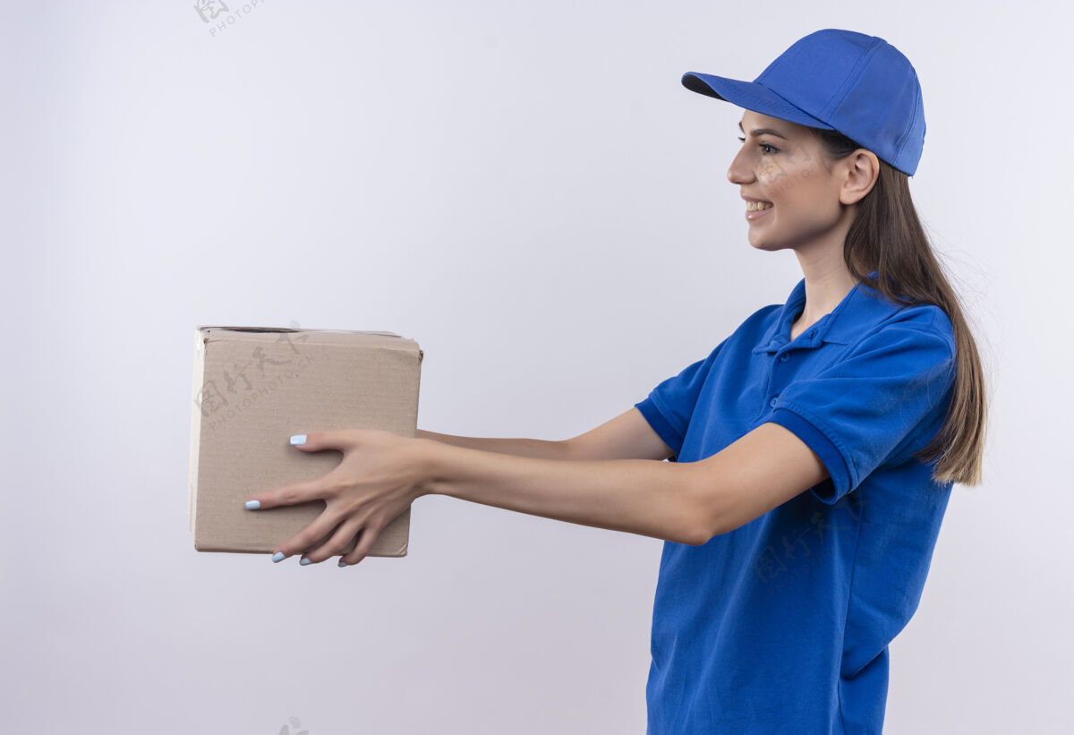 盒子身着蓝色制服 头戴帽子的年轻送货女孩微笑着向顾客赠送礼盒包装顾客蓝色微笑