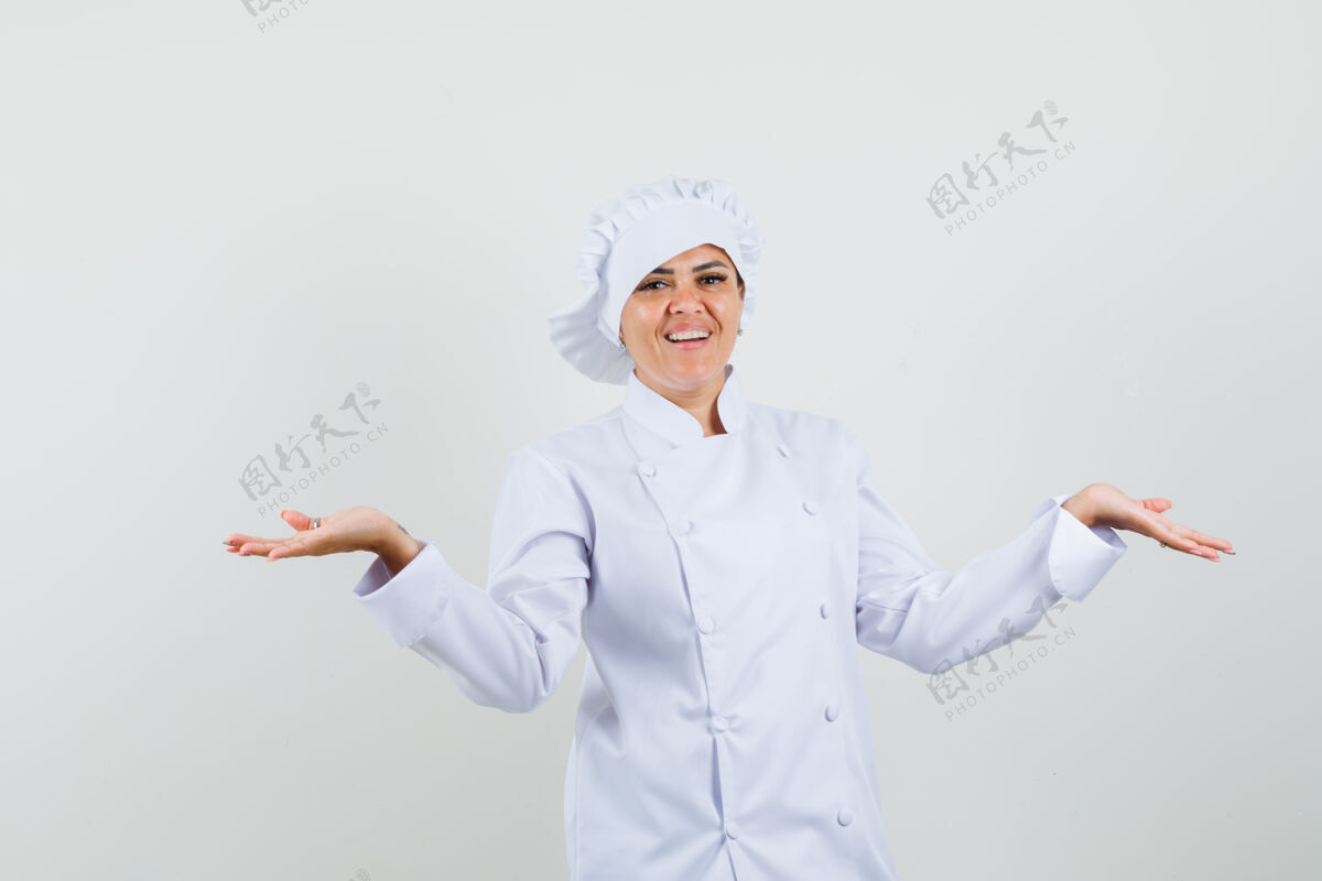 工作女厨师穿着白色制服 把手掌摊开 看上去很高兴帽子举行手掌