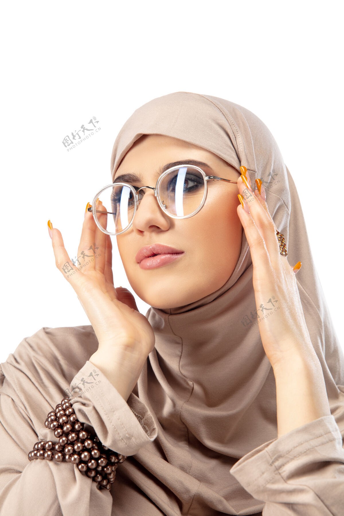 情绪粉彩美丽的阿拉伯妇女摆着时髦的头巾隔离在墙上时尚 美丽 风格的概念女模特与时尚化妆 美甲和配件运动阿拉伯语化妆