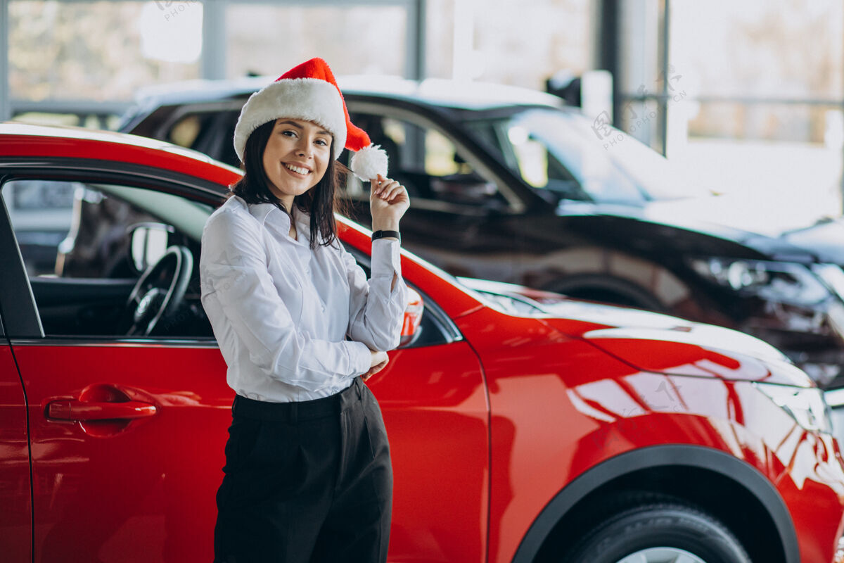 圣诞礼物圣诞节在汽车陈列室戴圣诞帽的女人客户彩票信心