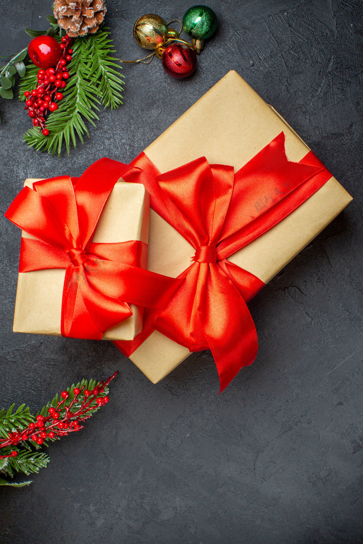 视图圣诞背景与蝴蝶结形彩带和杉木枝装饰配件上一个黑暗的表垂直视图美丽的礼物弓形冷杉轮子