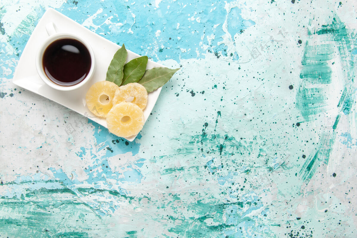 糖顶视图一杯茶 淡蓝色表面有干菠萝环饮料早上早餐