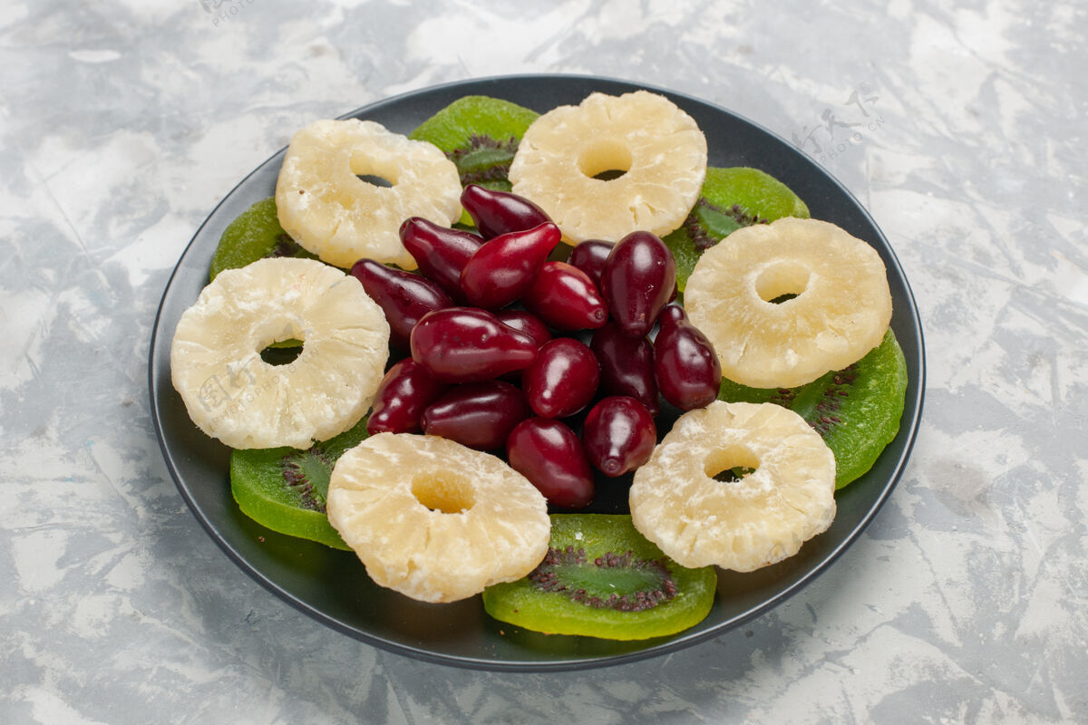 酸正面图：干果 菠萝环和白色表面的猕猴桃片餐饮食干