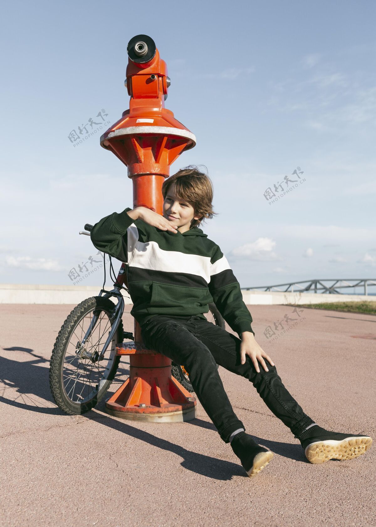 乐趣一个男孩骑着自行车在望远镜旁摆姿势户外户外活跃