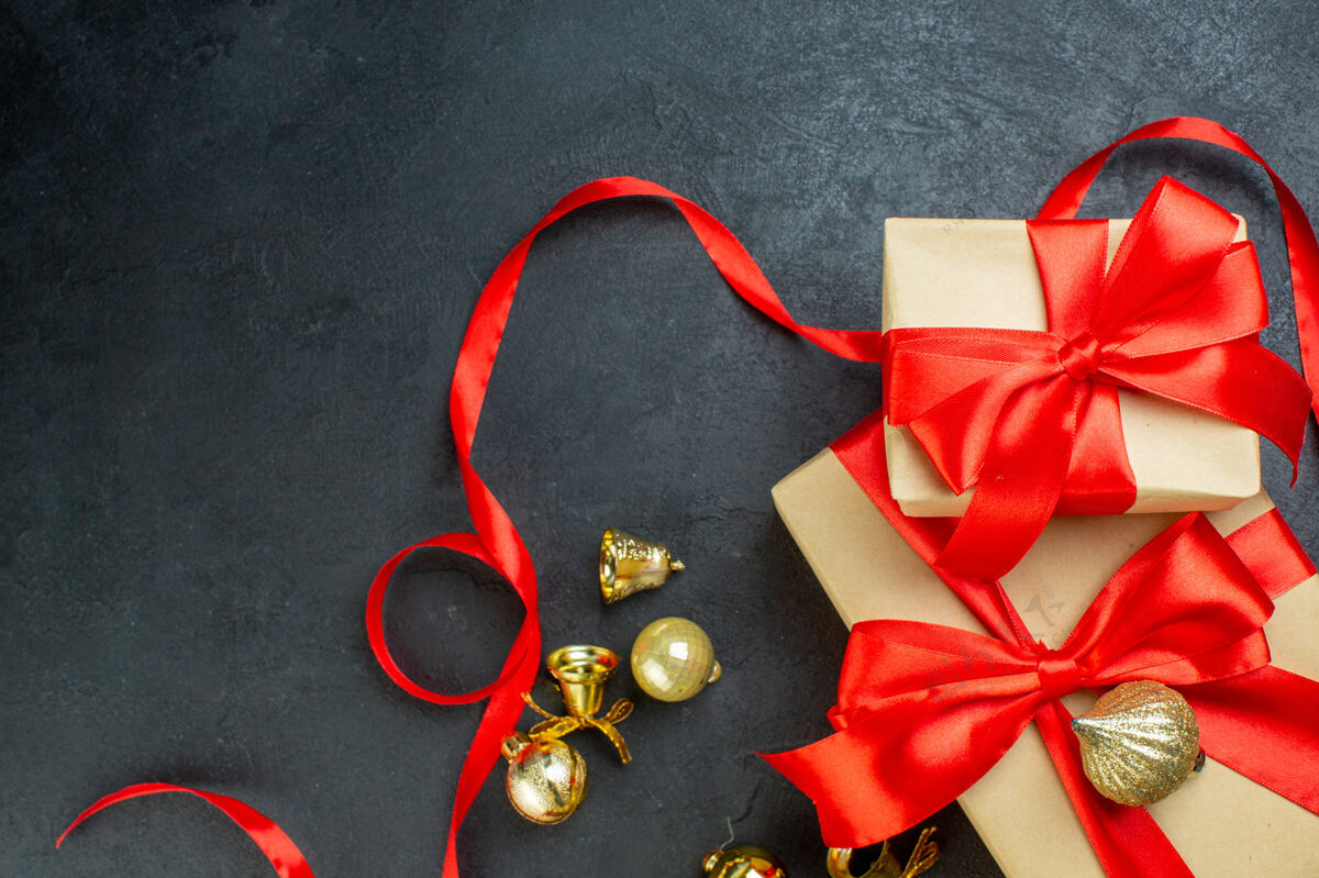 书签半拍的礼品盒与红丝带和装饰配件在黑暗的背景一半圣诞节礼品盒